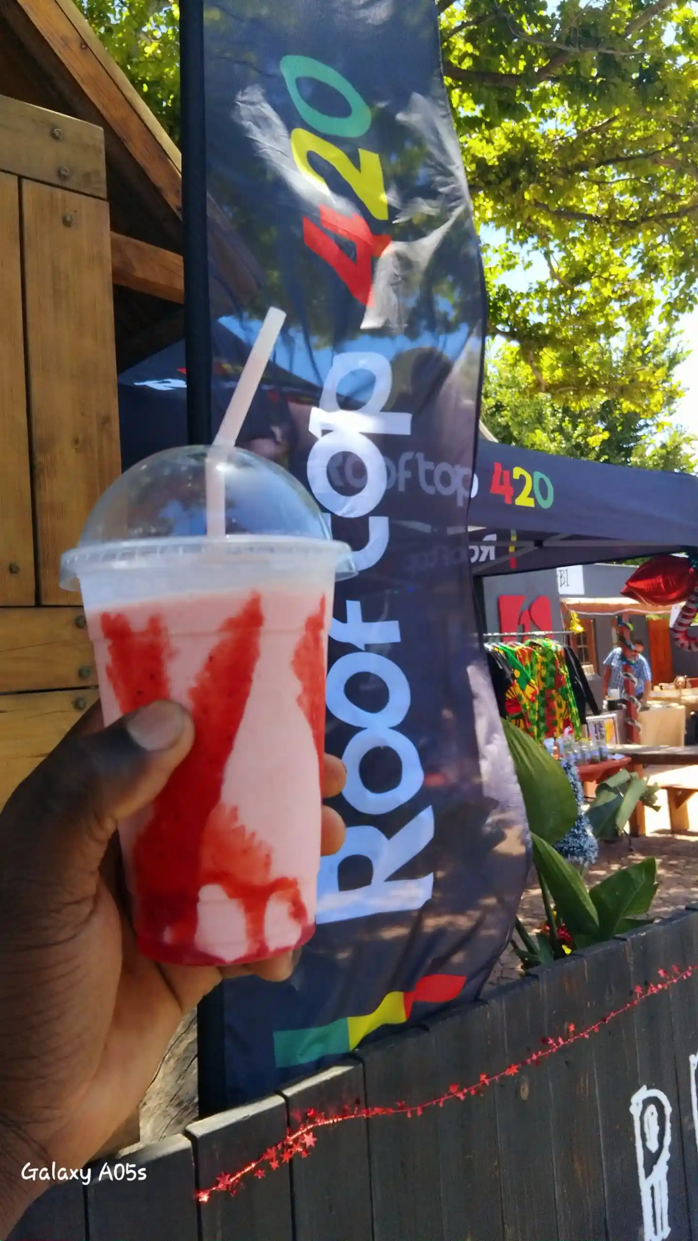 Strawberry frappé held up at an outdoor music event