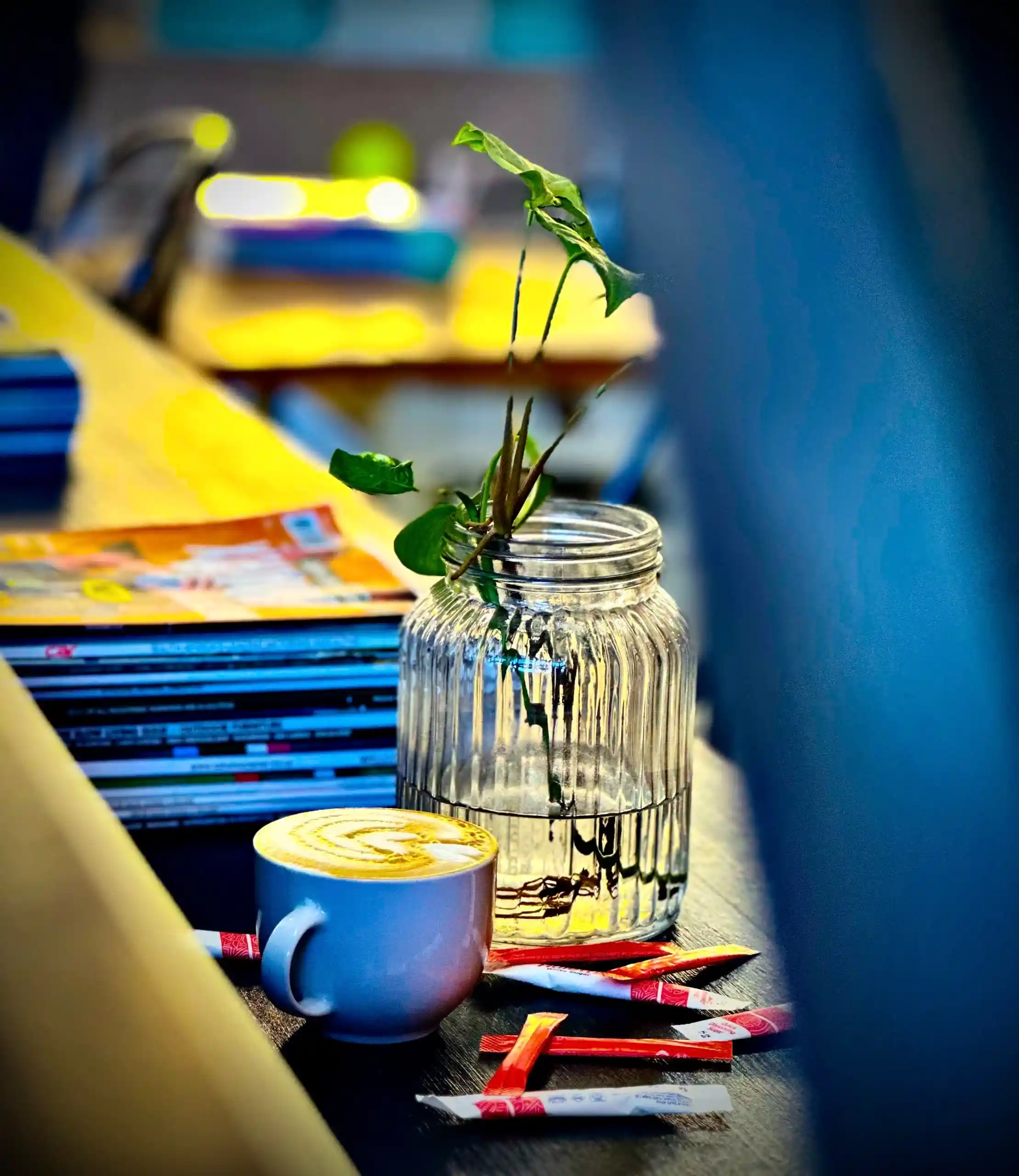 Moody latte with warm lighting next to a stack of books