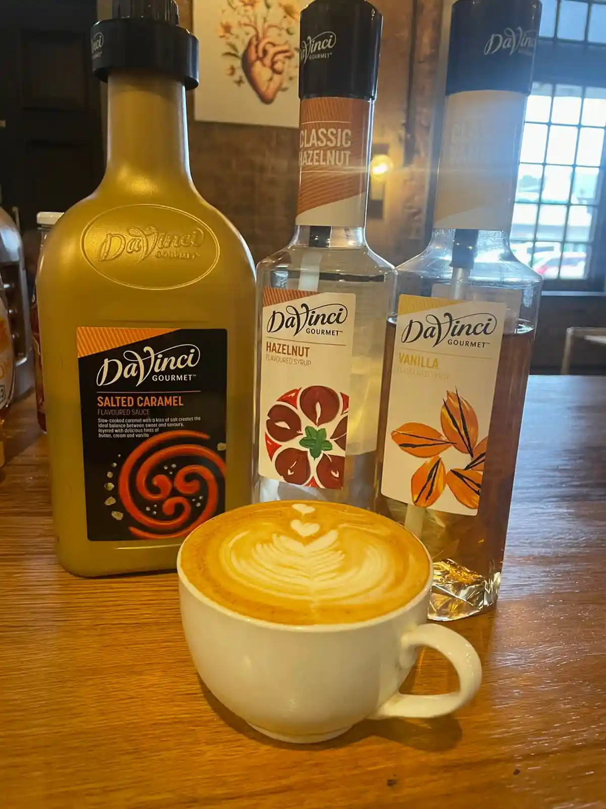 DaVinci Gourmet syrups arranged with a freshly prepared specialty latte